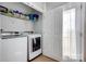 Functional laundry room featuring a washer, dryer, and storage shelves at 13610 Aldenbrook Dr, Huntersville, NC 28078