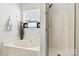 Bright bathroom featuring a garden tub, separate shower, and a window with decorative stained glass detail at 158 Bluffton Rd, Mooresville, NC 28115