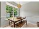 Bright dining area with a wooden table, bench seating, and a large window overlooking the backyard at 158 Bluffton Rd, Mooresville, NC 28115