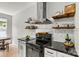 Updated kitchen with stainless steel appliances, granite countertops, floating shelves, and white and black cabinetry at 158 Bluffton Rd, Mooresville, NC 28115
