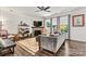 Comfortable living room featuring a ceiling fan, stone fireplace, large windows, and hardwood flooring at 158 Bluffton Rd, Mooresville, NC 28115