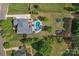 An aerial view of a property featuring a large pool with adjacent patio, trampoline and verdant green space at 1614 Crestgate Dr, Waxhaw, NC 28173