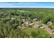 An aerial view of a neighborhood surrounded by lush greenery, featuring a home with an inviting swimming pool at 1614 Crestgate Dr, Waxhaw, NC 28173