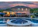 Luxurious pool and spa, surrounded by an expansive patio and a covered outdoor dining area with string lights at 1614 Crestgate Dr, Waxhaw, NC 28173