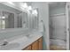 Bright bathroom featuring double vanity, framed mirror, and walk-in shower with glass doors at 1614 Crestgate Dr, Waxhaw, NC 28173