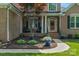 Inviting front porch with rocking chairs, decorative planters, and a red door, creating a welcoming entrance at 1614 Crestgate Dr, Waxhaw, NC 28173