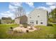 A backyard featuring a fire pit, surrounded by Adirondack chairs, on a well-manicured lawn at 1911 Almond Hills Dr, Charlotte, NC 28262