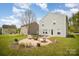 A backyard featuring a fire pit, surrounded by Adirondack chairs, on a well-manicured lawn at 1911 Almond Hills Dr, Charlotte, NC 28262