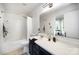 White bathroom with vanity, bathtub, shower, and a large mirror to create an open, airy feeling at 1911 Almond Hills Dr, Charlotte, NC 28262