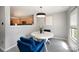 Cozy dining area with a white round table, blue chairs, modern chandelier, and view into the adjacent kitchen at 1911 Almond Hills Dr, Charlotte, NC 28262