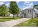 Landscaped front yard with a long driveway leading to a gray two-story home featuring an attached garage and well-maintained lawn at 1911 Almond Hills Dr, Charlotte, NC 28262