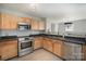 Bright kitchen featuring stainless steel appliances, wood cabinets, and a stainless steel sink at 1911 Almond Hills Dr, Charlotte, NC 28262