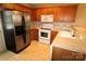 Well-lit kitchen with stainless steel refrigerator, white appliances, and wooden cabinets offering ample storage at 2043 Shady Pond Dr, Clover, SC 29710