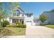 Charming two-story home with a well-manicured lawn and a two-car garage on a sunny day at 2207 Atwell Glen Ln, Pineville, NC 28134