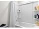 White bathtub and shower combination with a shower curtain and built-in shelving at 228 Brownstone Dr, Rock Hill, SC 29730