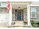 Inviting front porch with a blue door, decorative wreath, and charming stone accents at 228 Brownstone Dr, Rock Hill, SC 29730