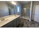Bathroom offers a double sink vanity, a large mirror, shower stall and black floor tiles at 228 Mountain Island Dr # 38, Statesville, NC 28677