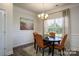 Elegant dining room with a chandelier, decorative molding, and a dark wood table with orange chairs at 228 Mountain Island Dr # 38, Statesville, NC 28677