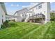 Spacious backyard with pristine lawn, a wooden deck, covered walkway and black fencing, ideal for outdoor activities at 2311 Lochview St, Pineville, NC 28134