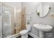 Clean bathroom with a glass-enclosed shower, pedestal sink, and neutral tiling at 2311 Lochview St, Pineville, NC 28134