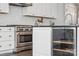 Close-up of a well-equipped kitchen featuring an oven, wine cooler, and white cabinets at 2311 Lochview St, Pineville, NC 28134