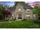 Stunning two-story home featuring manicured lawn and stone facade, complemented by lush landscaping at 2500 Giverny Dr, Charlotte, NC 28226