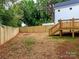 Large backyard features a wooden fence, and stairs leading to a deck by the house at 2501 Elon St, Charlotte, NC 28208