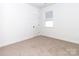 Clean bedroom featuring soft carpeting, a window, and a door leading to ample closet space at 2501 Elon St, Charlotte, NC 28208