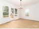 Light-filled dining room boasts hardwood floors and multiple windows, perfect for entertaining at 2501 Elon St, Charlotte, NC 28208