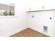 Well-lit laundry room features white cabinetry, a utility sink, and a window offering natural light at 2501 Elon St, Charlotte, NC 28208