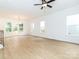 Spacious room with three windows, vinyl flooring, ceiling fan and access to an outdoor deck at 2501 Elon St, Charlotte, NC 28208