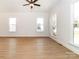 Bright living room with a ceiling fan, three windows, and vinyl flooring at 2501 Elon St, Charlotte, NC 28208