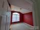 View from doorway of carpeted bedroom featuring a large window and red walls at 2527 Carya Pond Ln, Charlotte, NC 28212