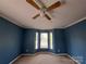 Blue bedroom features natural light from a bay window and overhead ceiling fan at 2527 Carya Pond Ln, Charlotte, NC 28212