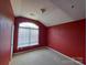 Cozy bedroom with neutral carpet, red walls, and natural light from the large window at 2527 Carya Pond Ln, Charlotte, NC 28212