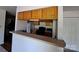 Cozy kitchen featuring wood cabinets, a breakfast bar, and standard appliances for a functional space at 2527 Carya Pond Ln, Charlotte, NC 28212