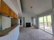 Open living room with vaulted ceilings, fireplace, built-in shelving, and sliding glass door to a deck at 2527 Carya Pond Ln, Charlotte, NC 28212