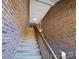 A wood staircase leads to a townhome's entrance, flanked by textured brick walls on each side at 2527 Carya Pond Ln, Charlotte, NC 28212