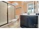 Tiled bathroom featuring a shower with glass doors, toilet, and single sink vanity at 2533 Ensemble Ct, Charlotte, NC 28262
