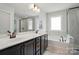 Spacious bathroom featuring a double vanity, soaking tub, large windows, and a glass enclosed shower at 2533 Ensemble Ct, Charlotte, NC 28262