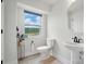 Bright, minimalist bathroom featuring a pedestal sink, toilet, and natural light at 2533 Ensemble Ct, Charlotte, NC 28262