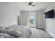 Bright bedroom featuring carpeted floors, ceiling fan, television, and a door that leads to a balcony at 2533 Ensemble Ct, Charlotte, NC 28262