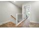 Hallway with carpeted floor and railing leading to a bedroom with an exterior door at 2533 Ensemble Ct, Charlotte, NC 28262