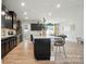 Open-concept kitchen with island, dark cabinets, and stainless steel appliances seamlessly connects to living and dining areas at 2533 Ensemble Ct, Charlotte, NC 28262