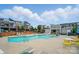 Community pool and clubhouse with lounge chairs, tables, and umbrellas offering residents a relaxing outdoor oasis at 2533 Ensemble Ct, Charlotte, NC 28262