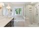 Modern bathroom features a glass-enclosed shower, soaking tub, and black and white color palette at 2621 Huntman Way, Charlotte, NC 28226