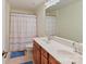 Well-lit bathroom with double vanity, framed mirror, neutral tile, and a shower-tub combo with colorful curtain at 2621 Huntman Way, Charlotte, NC 28226
