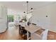 Dining room with modern decor, wood floors, an abundance of natural light, and seamless flow to the kitchen and living spaces at 2621 Huntman Way, Charlotte, NC 28226