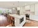 Bright white kitchen featuring a large center island with barstool seating, stainless appliances, and open to the living spaces at 2621 Huntman Way, Charlotte, NC 28226