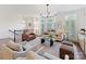 Cozy living room featuring a leather armchair, modern furniture, large windows, and seamless flow to the kitchen and dining area at 2621 Huntman Way, Charlotte, NC 28226